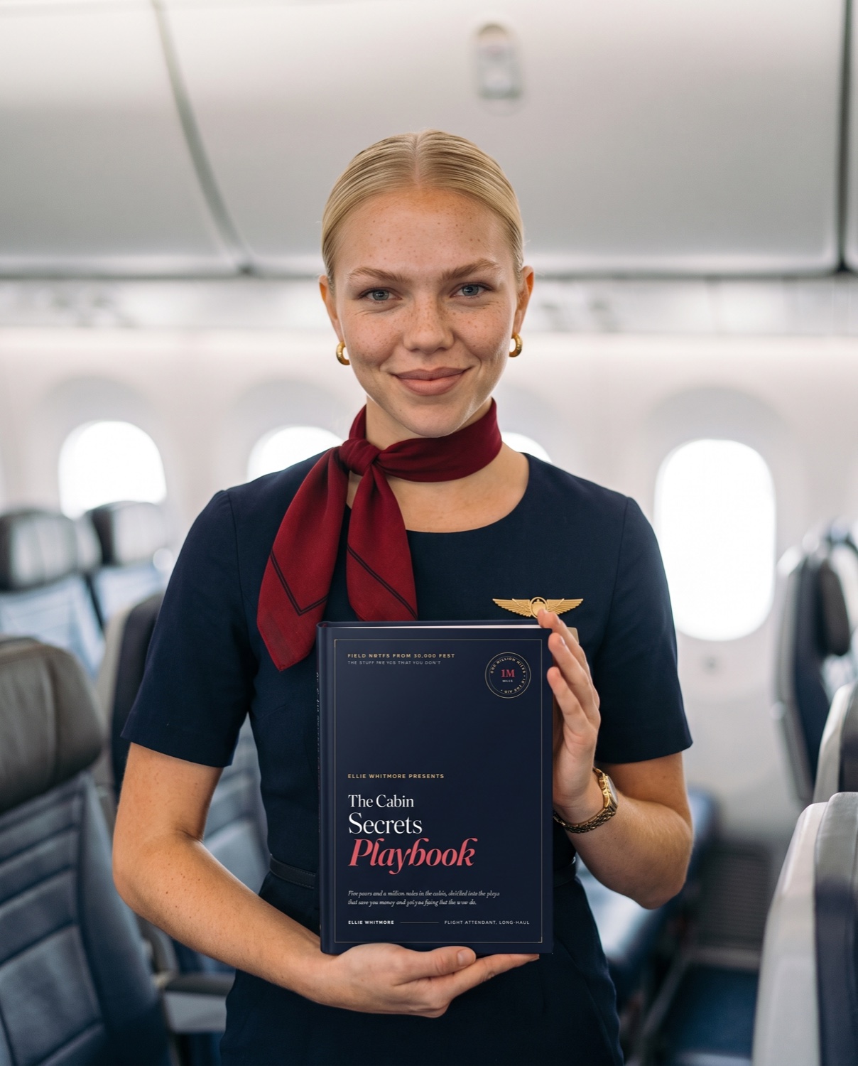Ellie Whitmore holding her Cabin Secrets Playbook in the cabin